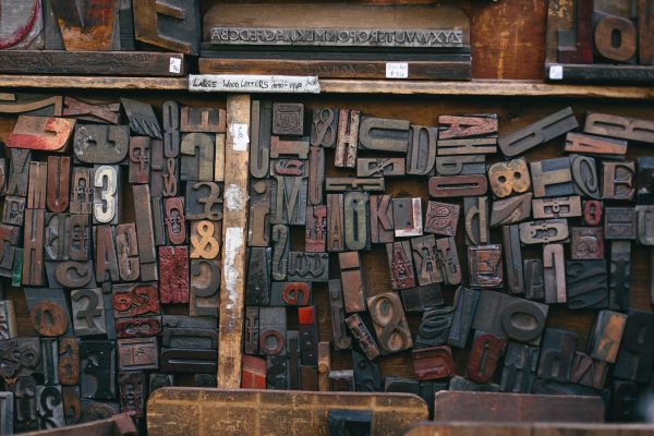 A drawer containing an assortment of wooden letters used in printing.