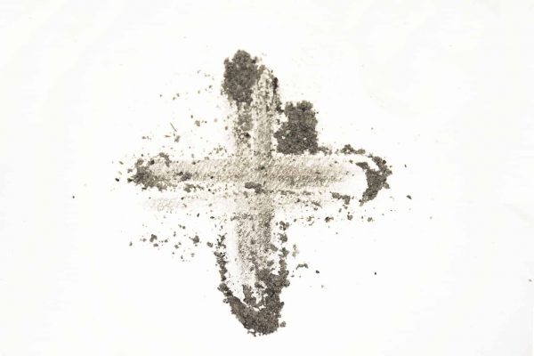 Gray-brown ash is drawn in the shape of a cross against a white background.