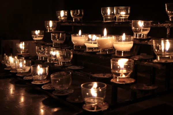prayer candles, votives lit in glass holders